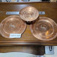 Top view of two plates and compote showing engraving and copper finish