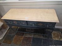 Full view of console table showing beige top, two drawers, metal legs and lower shelf