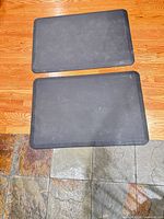 Two black rectangular WeatherTech mats on floor
