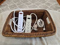 basket containing power strips and cords