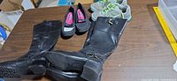 All three pairs on table: boots, sneakers, flats