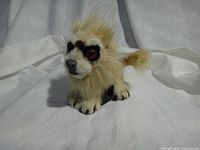 Front view of fur-covered bobblehead figurine showing glass eyes and paw details