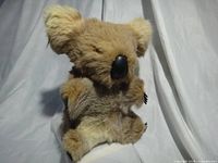 Front view of tan real-fur koala bear plush showing black nose, eyes, paws