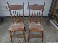 Front view of two brown painted wooden chairs