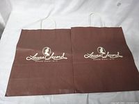 Front view of two brown Laura Secord paper bags with handles