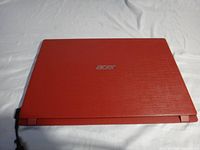 Closed red Acer laptop top view