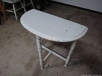 Top view of half-moon table showing paint chips and shape