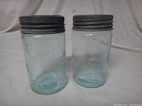 Front view of two aqua blue Crown Mason jars with zinc lids