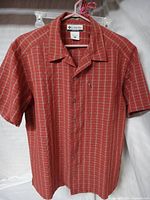 Front view of Columbia red plaid short-sleeve shirt on hanger