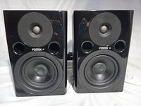 Front view of both speakers showing drivers and ports