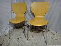 Front view of two bentwood chairs showing seat shape and chrome legs