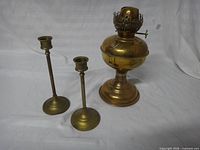 Front view showing brass oil lamp base with burner and two candlesticks