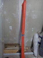 Full view of rolled orange tarp standing vertically