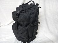 Front view showing main compartments, MOLLE webbing, D-ring, top handle and compression straps