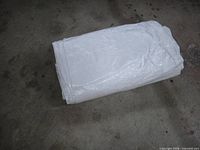 Folded white tarp on floor