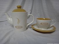 Teapot with lid, matching cup and saucer, Tim Hortons branding visible