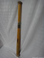 Full view of wooden Cooper youth baseball bat standing upright