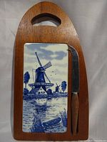 Front view of cheese board showing Delft-style tile and knife seated in groove