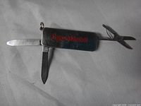 Multi-tool open displaying nail file, knife blade, and scissors