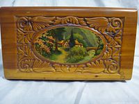 Top view showing carved border and painted cottage scene on lid