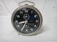 Front view showing black dial, numerals, subsidiary dials, hands and case