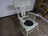 Three-quarter front view of light green rocking chair showing overall form and paint