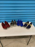 All four pairs of Nike sneakers lined side by side on table