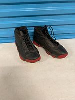 Pair of black and red Air Jordan 13 sneakers side by side