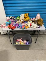 Full view of table and bin with all plush items