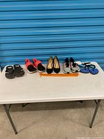 All five pairs of footwear on table with measuring stick