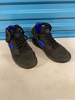 Pair of black and blue Nike Air Huarache youth sneakers front view