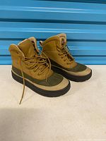 Side view of both Nike ACG duck boots showing uppers, soles, and overall condition