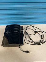 Top of PlayStation 3 console with cables beside