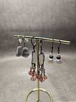 Front view showing three pairs of sterling silver earrings on stand