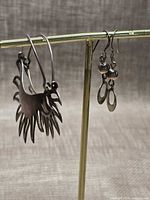 Both earring pairs hanging on display bar