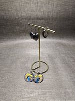 All three pairs of silver earrings displayed on stand