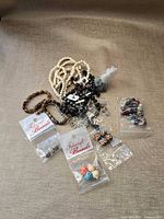 Lot overview showing all bead strands, packaged Fabucraft beads, bags of loose beads, chain