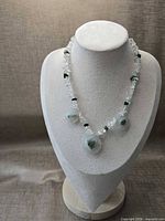 Full view of necklace on display bust showing overall design and bead arrangement