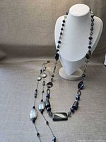 Both necklaces draped on bust form showing full lengths and bead variety