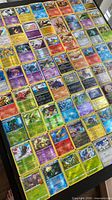 Full layout of approximately 150 holographic/reverse holo Pokémon cards on table