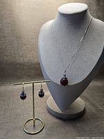Full view of necklace on bust and earrings on stand