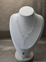 Full view of necklace on display bust showing geometric link chain and pendant