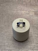 Front view of sterling silver ring displaying raised "M" initial