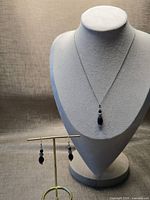 Full view of necklace and earrings on stands