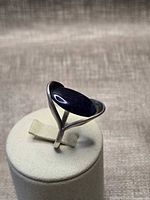 Three-quarter view showing open sculptural setting and marquise cabochon