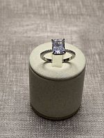 Full view of ring on display stand showing center stone and band