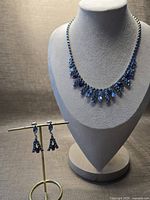 Necklace on bust and earrings on stand, full set view