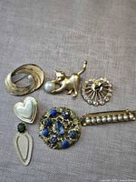 Group shot of all six brooches on fabric background