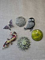 All six brooches laid out showing shapes and colours