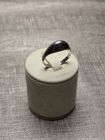 Front view of polished sterling silver dome ring on display stand